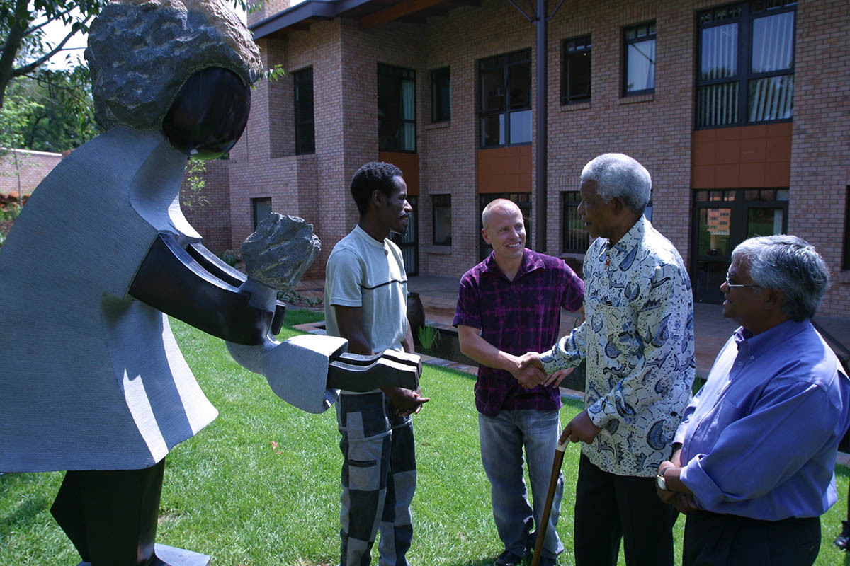 Mandela presenting his sculpture to a group